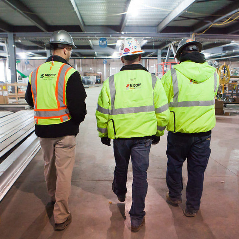 Mid-City team with hard hats walking through a building